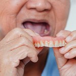 Patient removes dentures